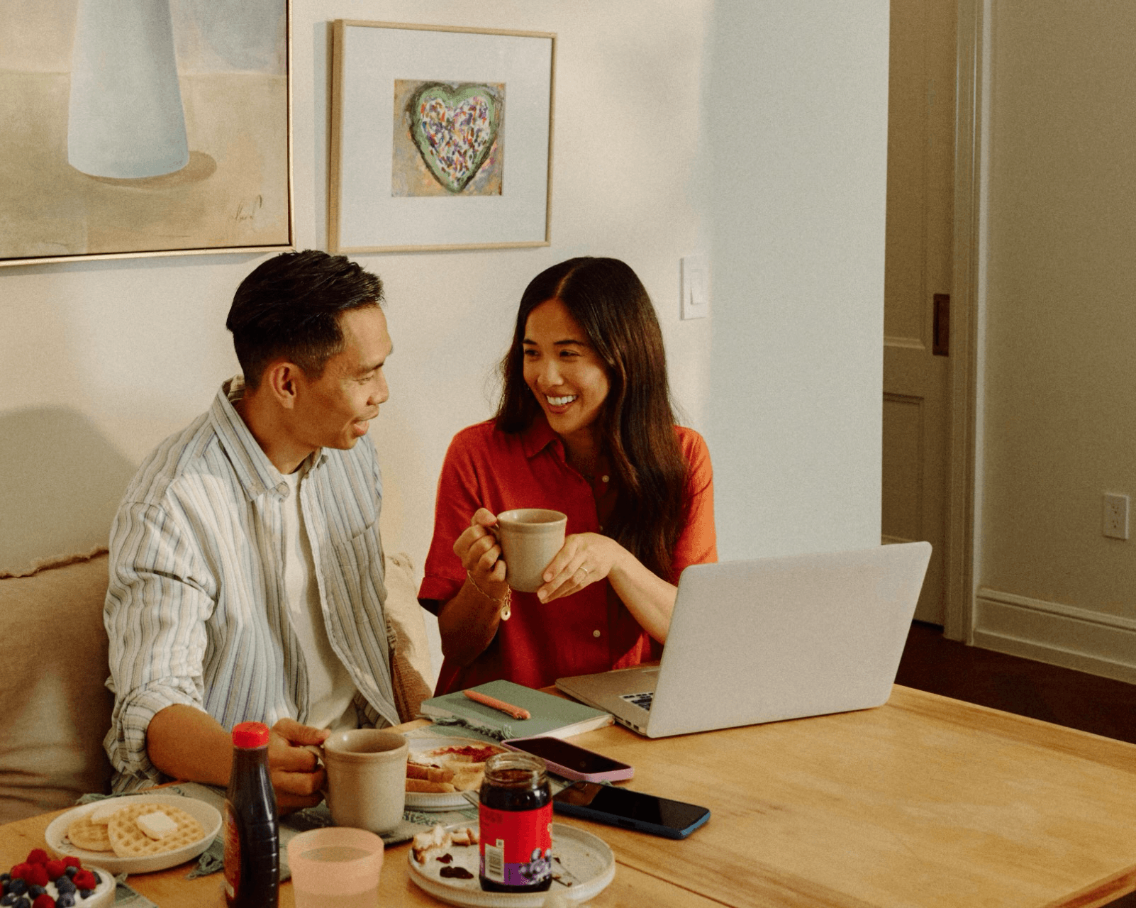 Couple smiling while looking at a laptop at home