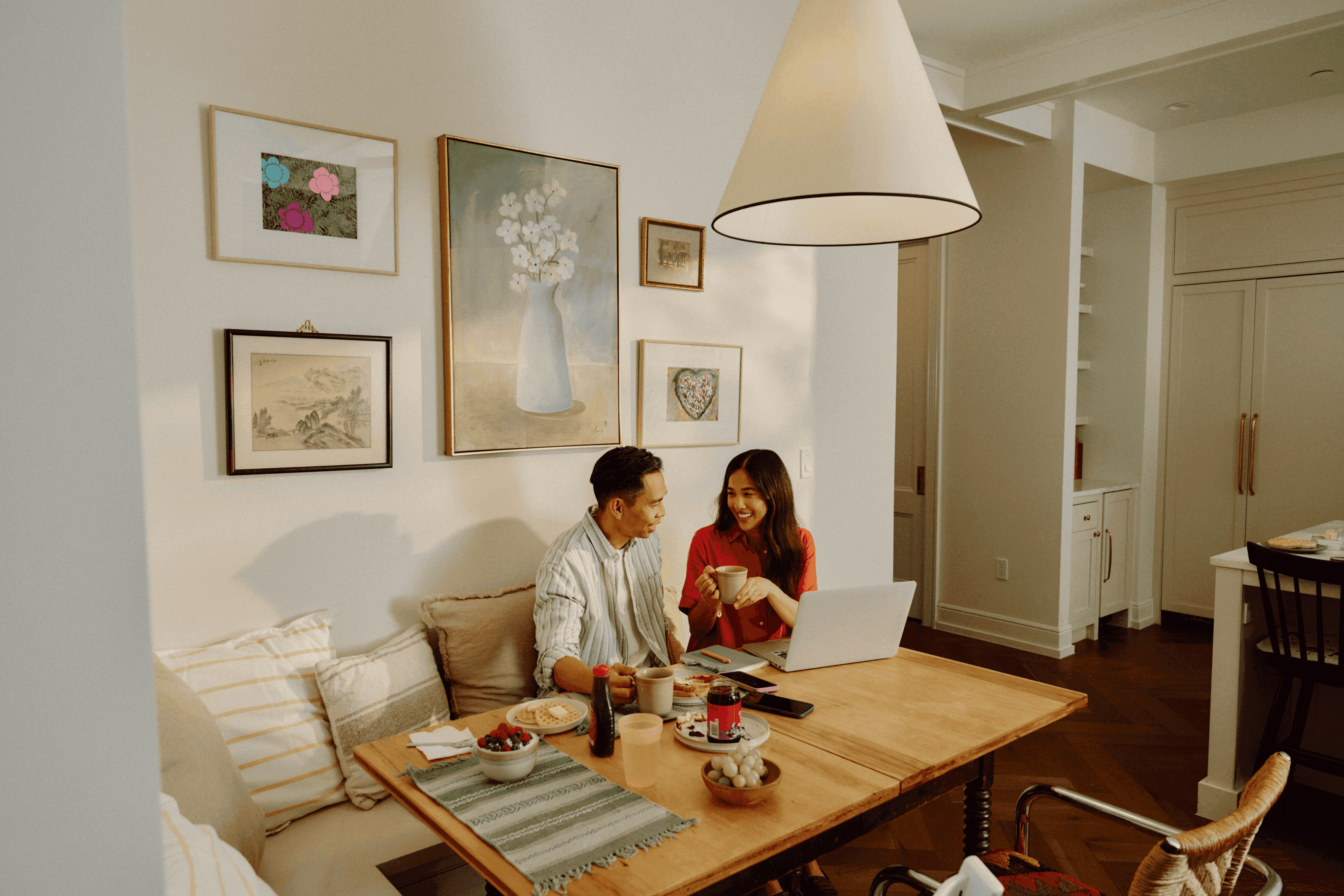 Couple smiling while looking at a laptop at home